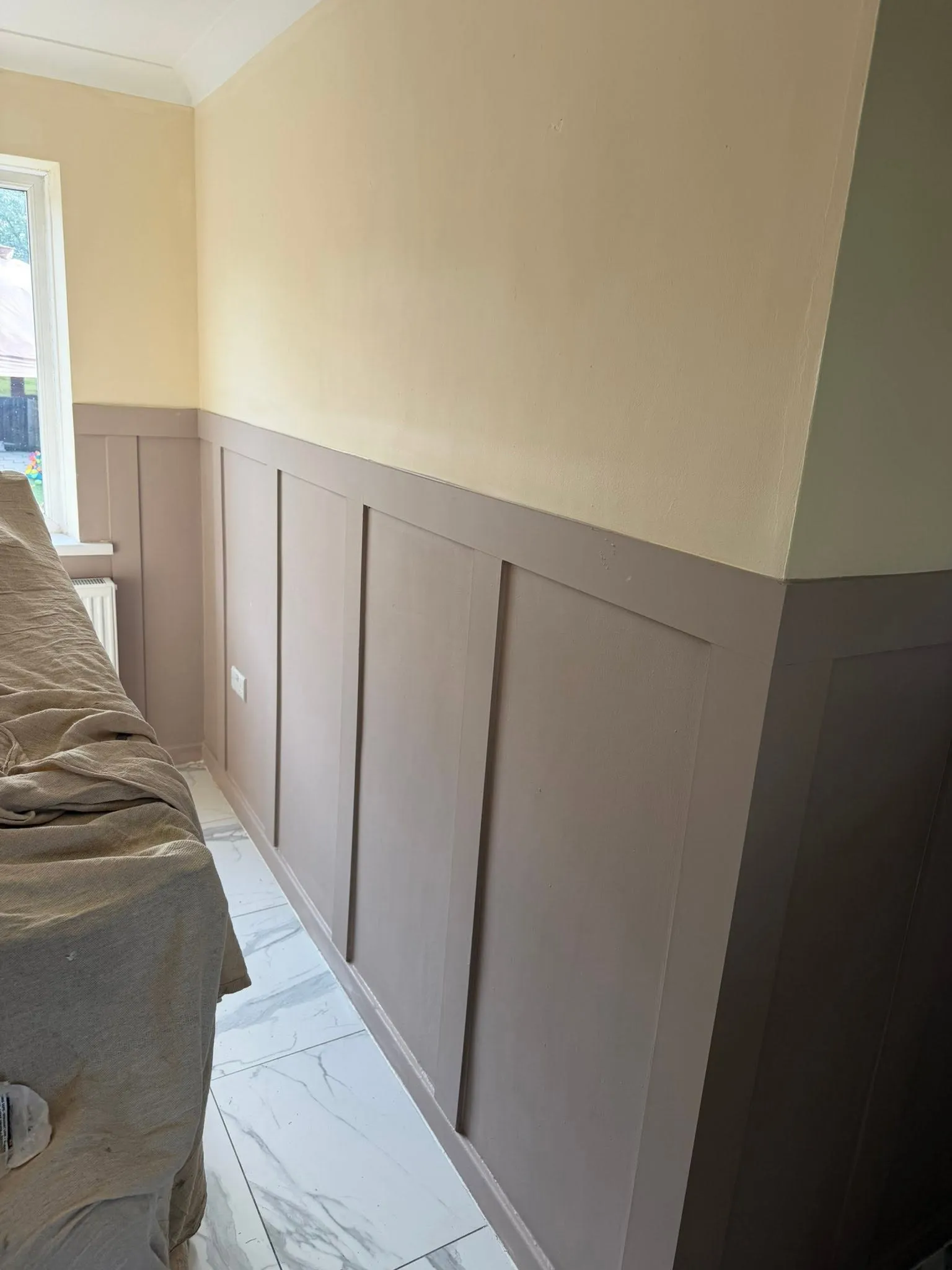 The finished wall panelling painted in a soft mushroom colour